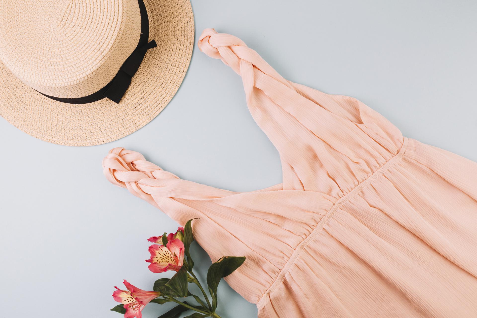 Close view of light pink dress with a hat and flowers